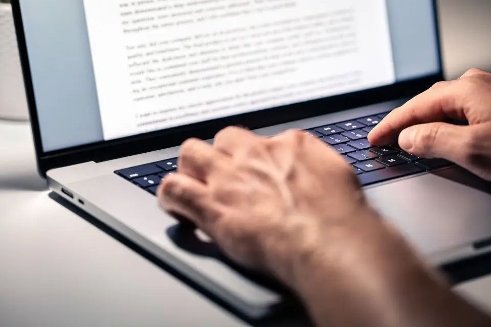Hands typing on a laptop keyboard